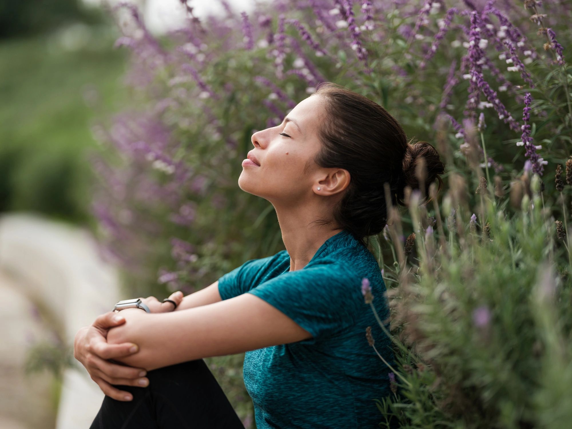 Woman relaxing peacefully beside flowers